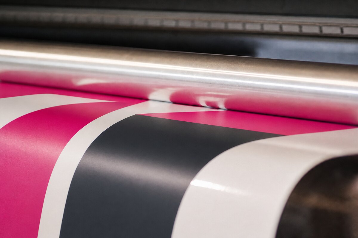 Close-up of large-format print moving through a production machine